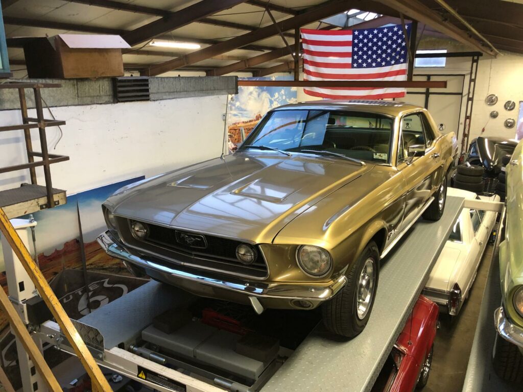 Ford Mustang Coupé in Gold auf Hebebühne von vorne