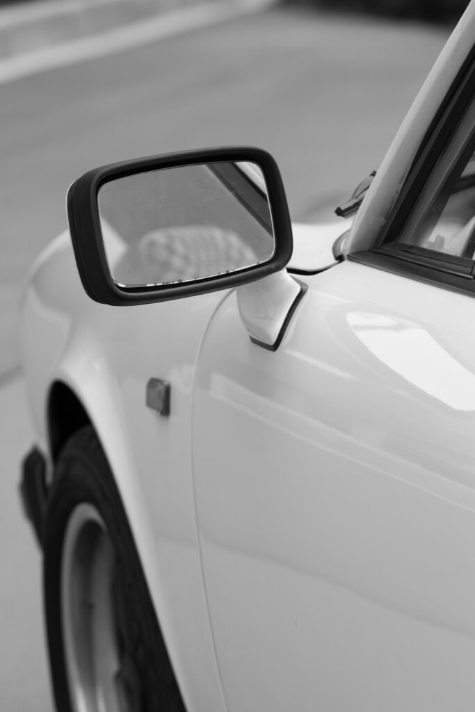 Linker Seitenspiegel in Schwarz von weißem Porsche 911 SC Targa weiß seitlich links