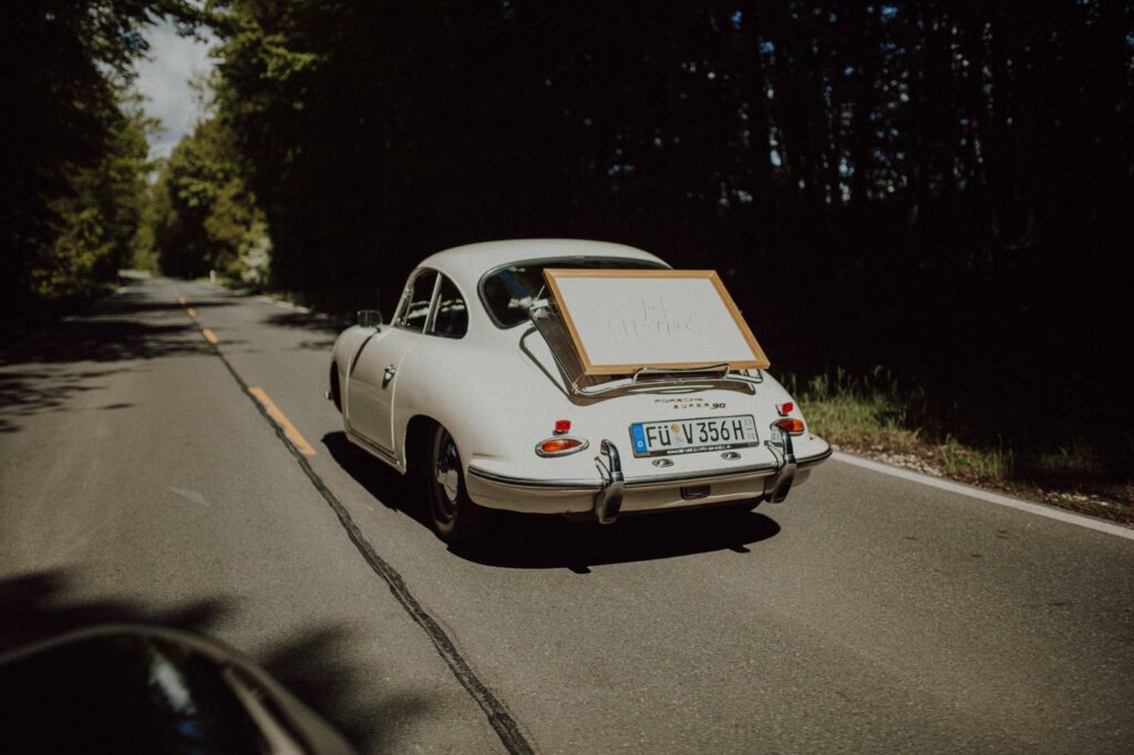 Porsche 356 Coupé in Cremeweiß von hinten mit Hochzeitsschild "just married"